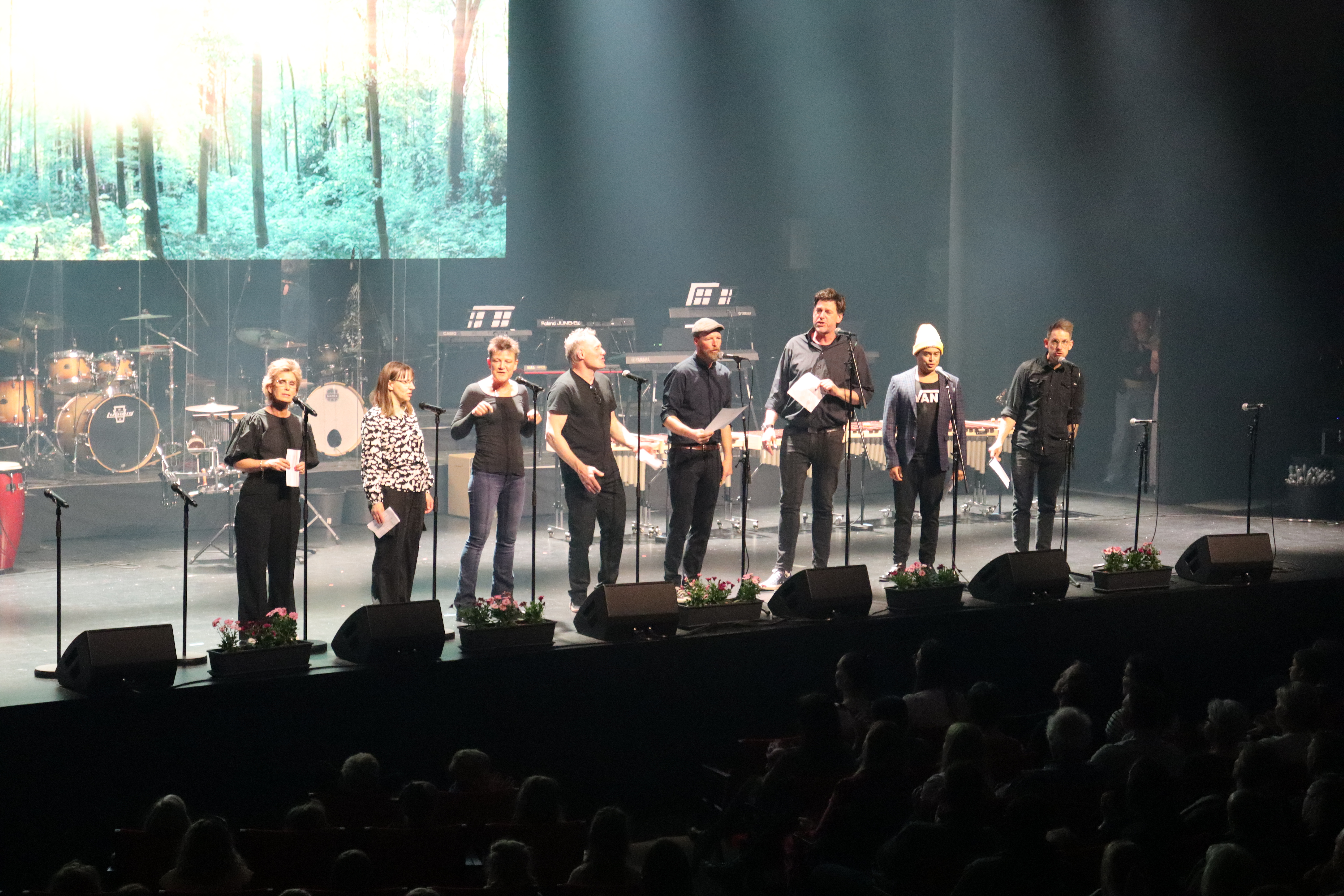 Musiklærere står på en musikscene og synger en sang